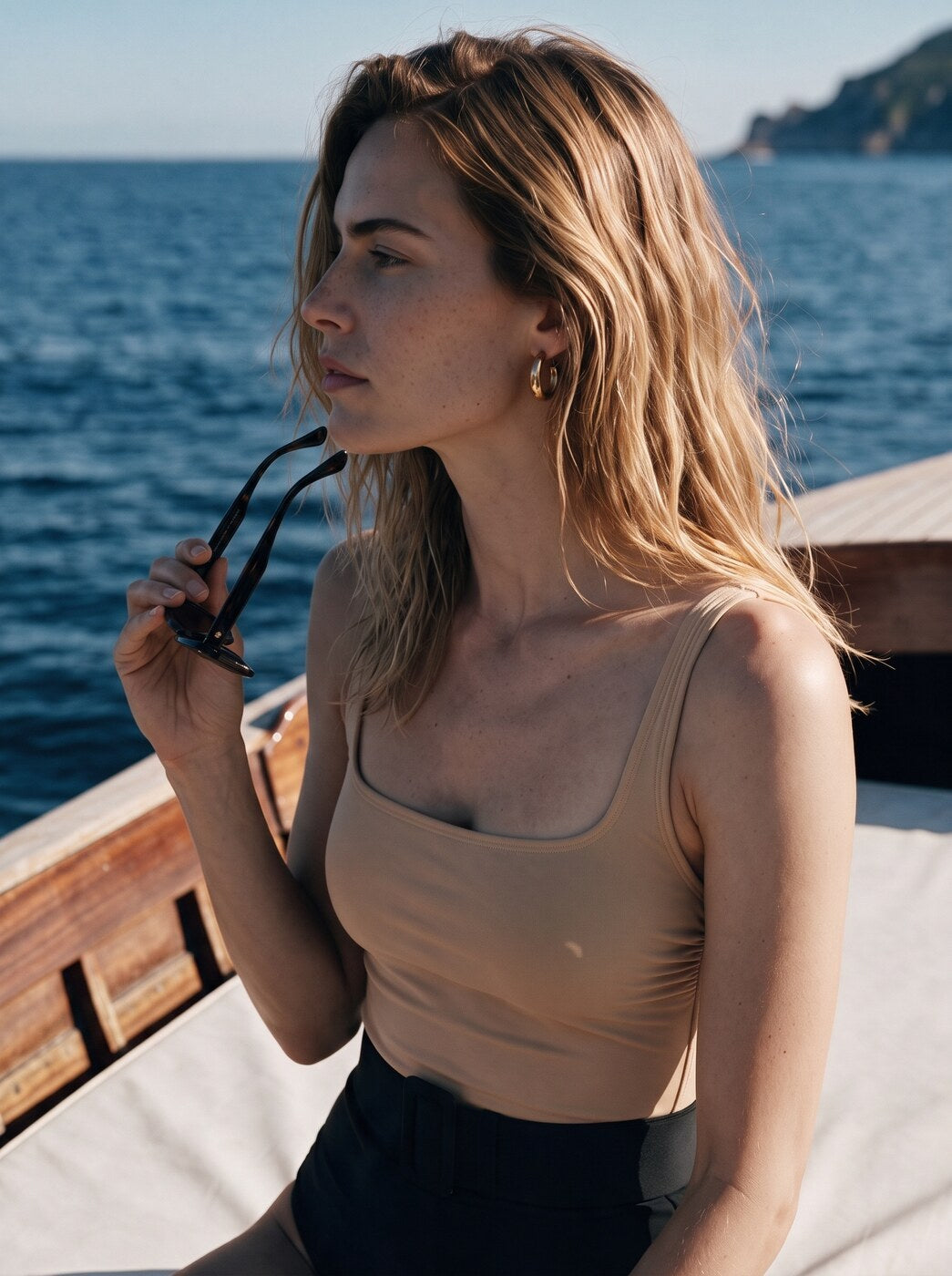 On the bow, sunglasses in hand